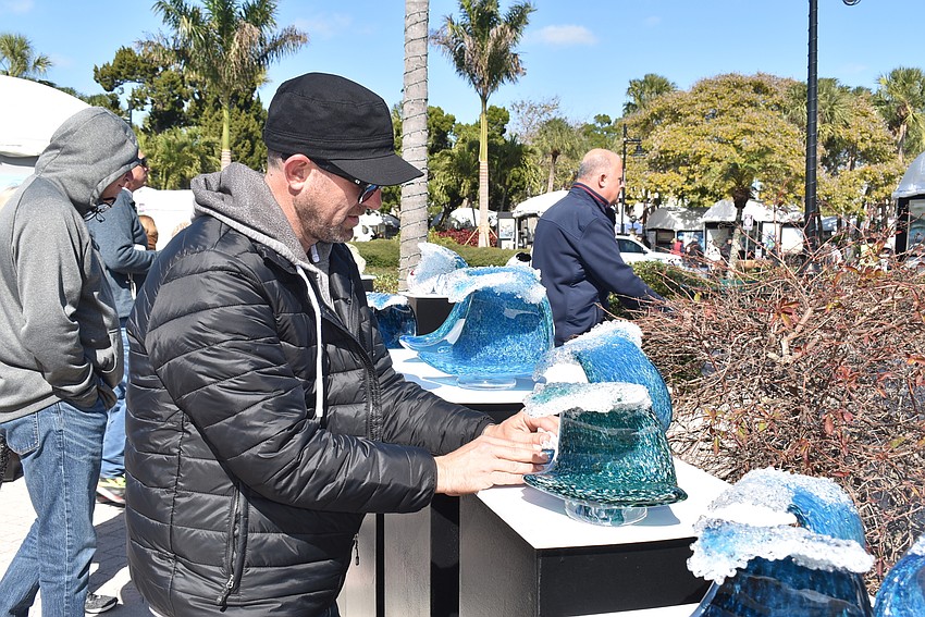 Josh Fradis wipes down some of his glass art.