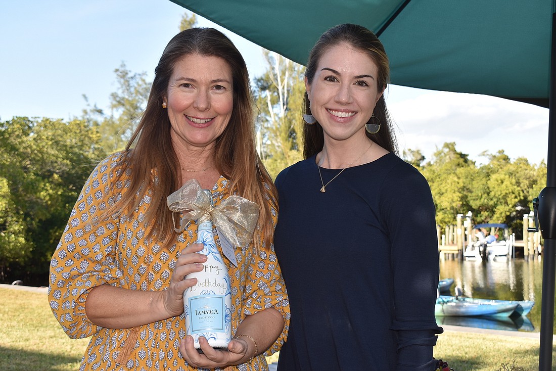 Heather Rippy and Stephanie Troxler with a bottle of prosecco Troxler painted for the occasion.