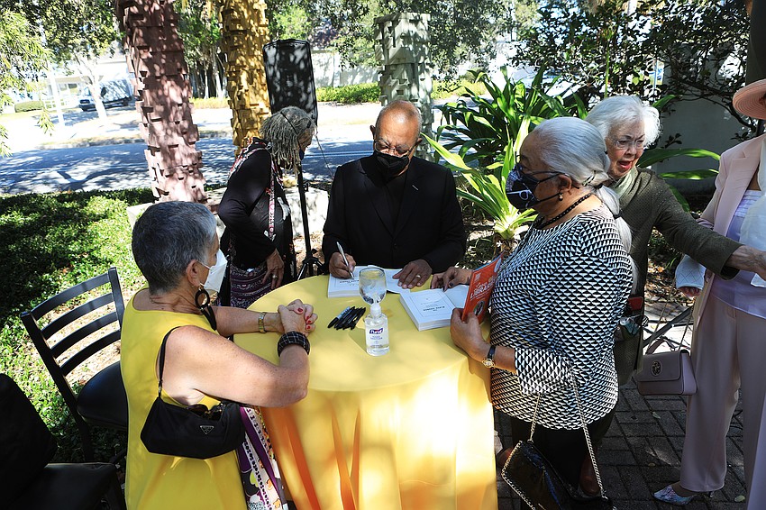 Dr. Henry Louis Gates Jr.  signs books for an eager audience.