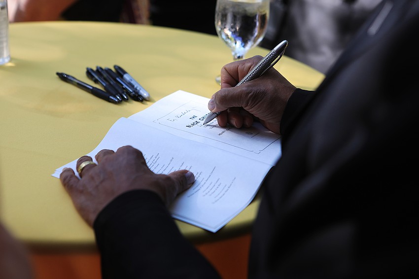 Dr. Henry Louis Gates Jr.  signs books for an eager audience.
