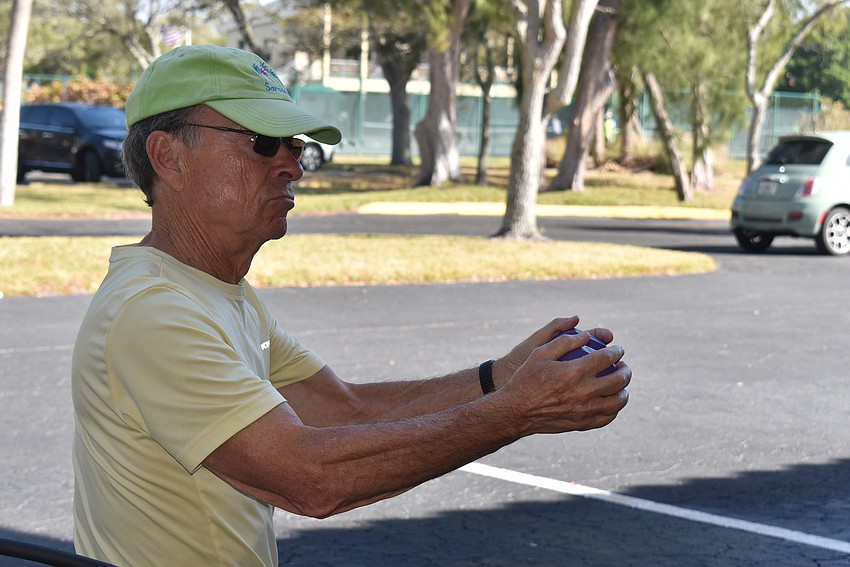 Peter Mermin twists with a weight during Stretch and Strengthen.