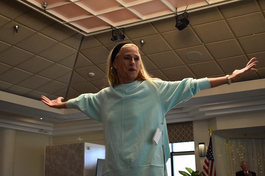 Kay Kwenski, a Palm Aire Women's Club fashion show committee member, spreads her wings on the runway.