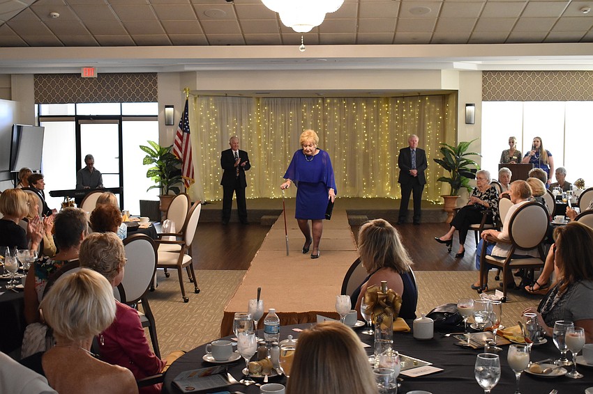 Everyone in the room watches as Joan Greene walks the runway.