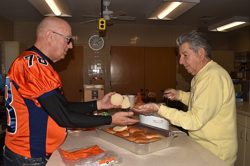 Chuck Sobieck and Lenny DiStefano put together pulled pork sandwiches.