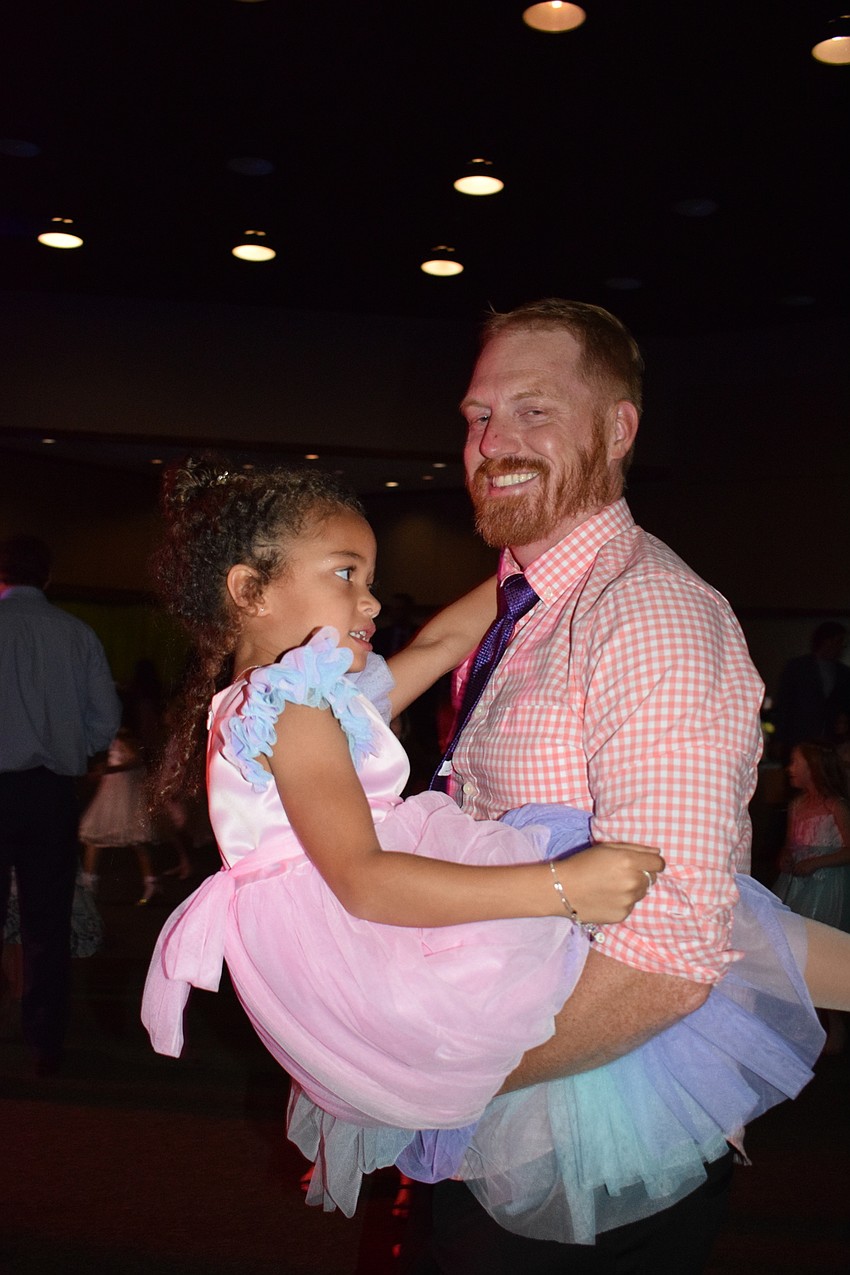 Cassiel Mueller, a kindergartner, dances with her dad, Paul Mueller. Paul Mueller says it's awesome to be at their first father-daughter dance.