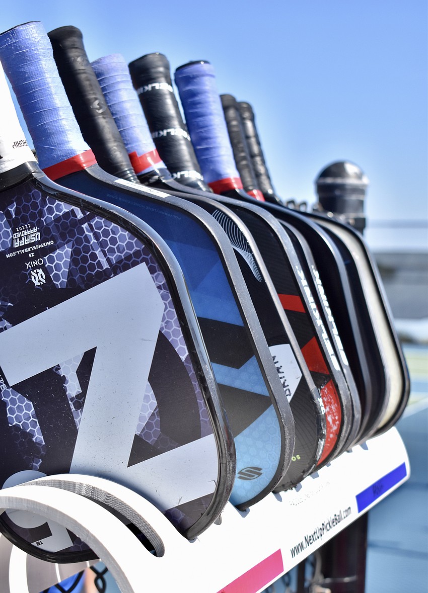 Players queue up for a match by placing their paddle in a rack designed for the purpose.