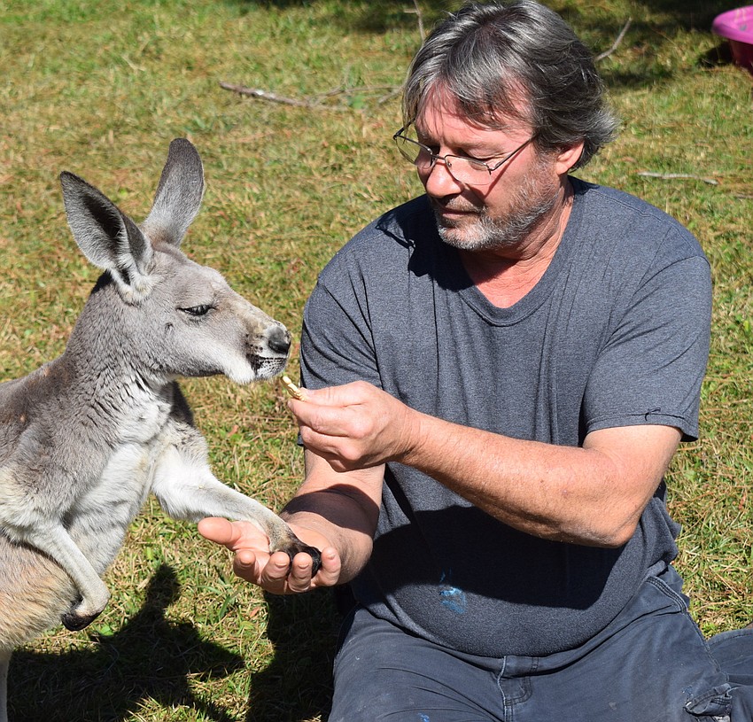 Dave Burns holds Emily's hands while offering a treat.