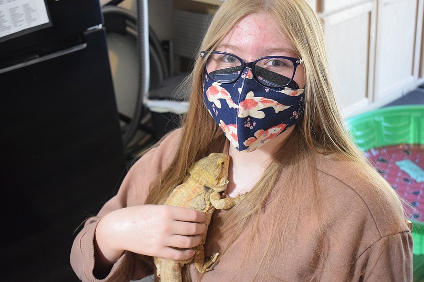 Volunteer Grace Parry, a student at Lakewood Ranch High School, gets close to a bearded dragon.