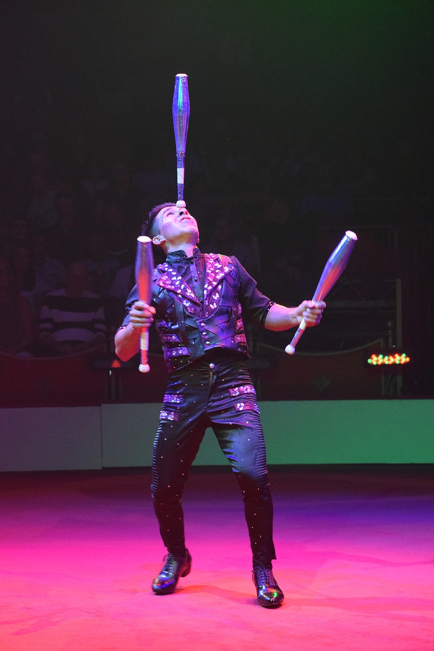 Nilson Escobar balances a pin on his forehead while juggling.