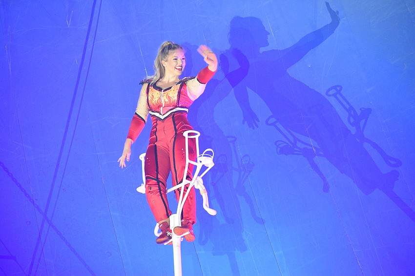 Annaliese Nock waves to the crowd on top of a sway pole dozens of feet above ground.