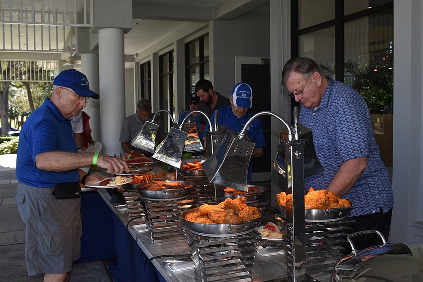 As golf ended, more attendees came in and loaded plates with hot dogs, burgers and fried chicken.