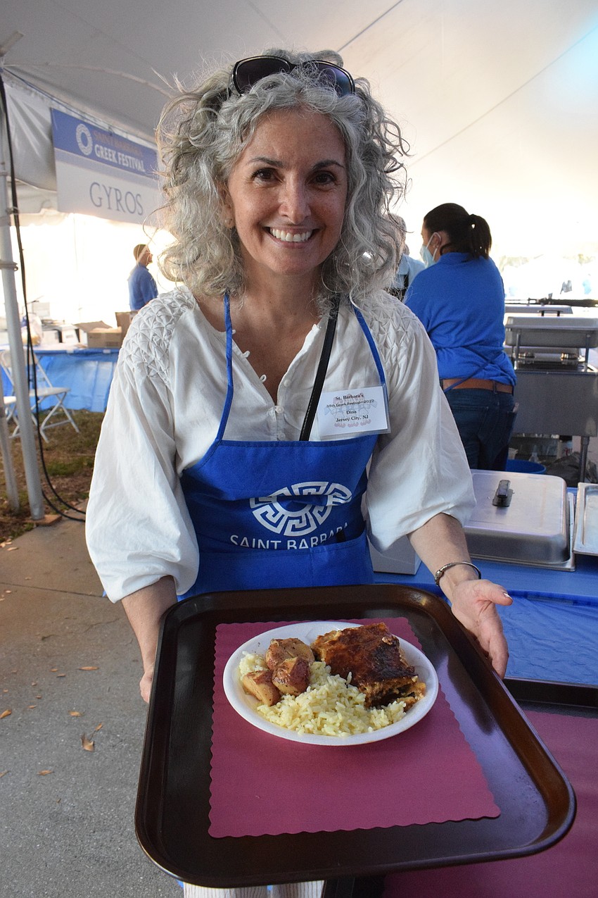 Greek Glendi volunteer Dina Hobson serves up a plate of moussaka with rice and potatoes.
