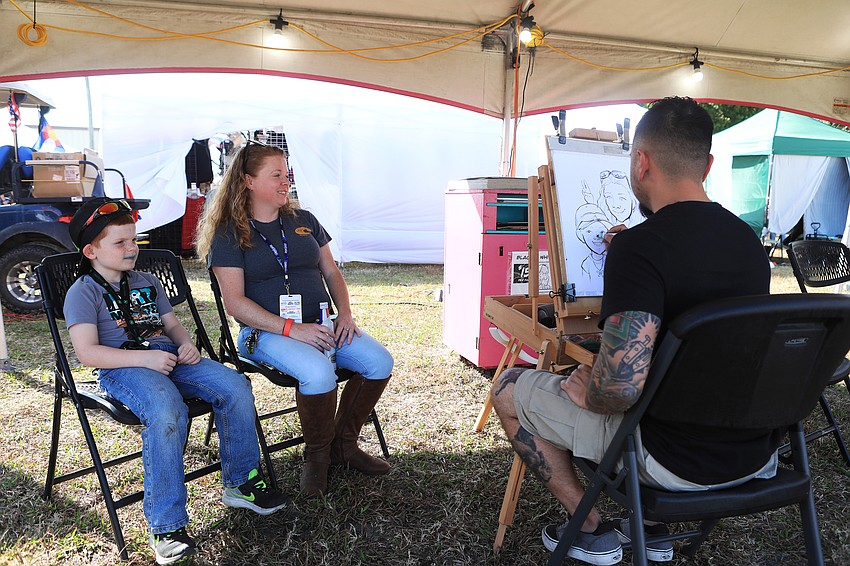 Stephannie Mullinnix and Eli Davis have their likenesses drawn by Eric Kaczynski