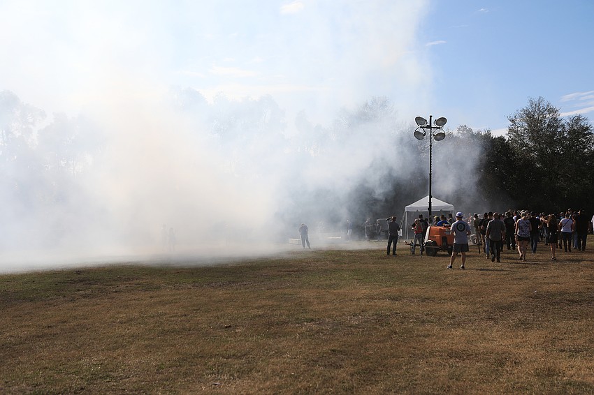 A tire blowout competition kicks up a cloud.