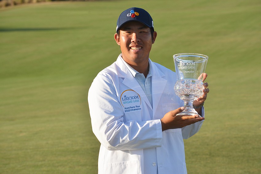 Byeong Hun An holds up the 2022 LECOM Suncoast Classic trophy after winning the tournament at 17 under par (65-66-67-69—267).