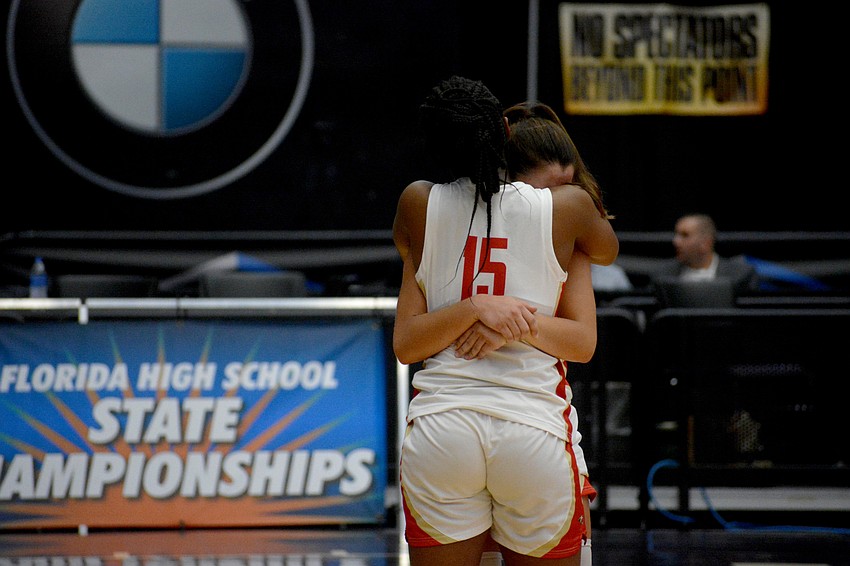 Cardinal Mooney freshman Sy'monique Simon (15) and senior Natalie Mercadante hug after Mooney's state championship loss to Westminster Academy.