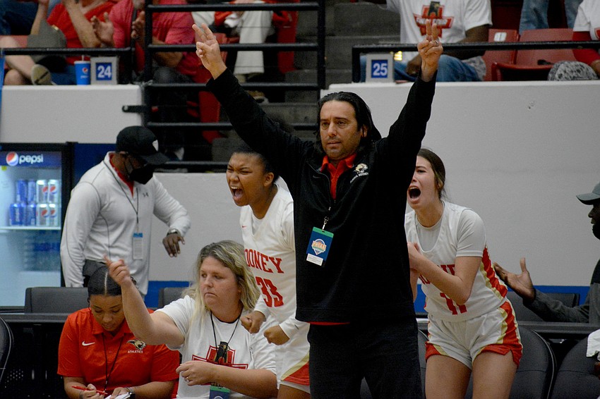 Mooney head Coach Rico Antonio and the Cougars bench celebrate a three-pointer from freshman Kali Barrett.