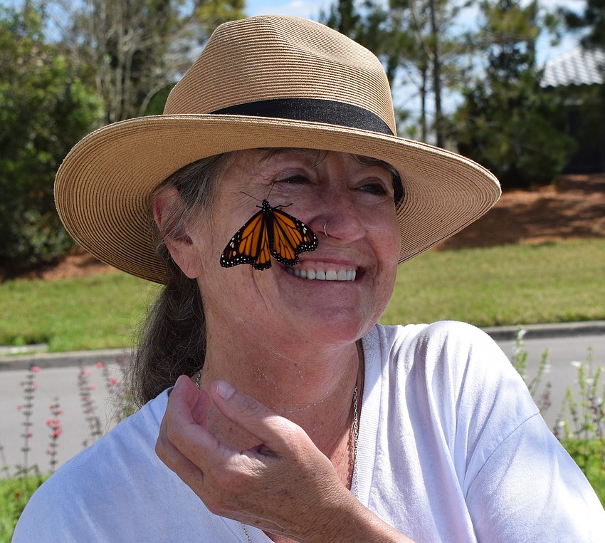 Del Webb's Shellie Robin gets a laugh when a monarch butterfly lands on her face.