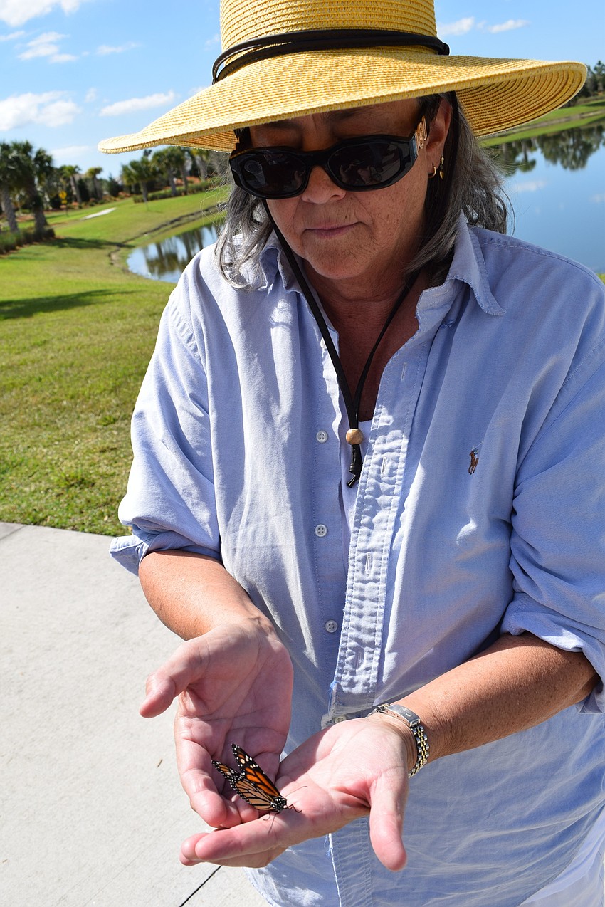 Joette Robin shows off a monarch butterfly being released into the garden.