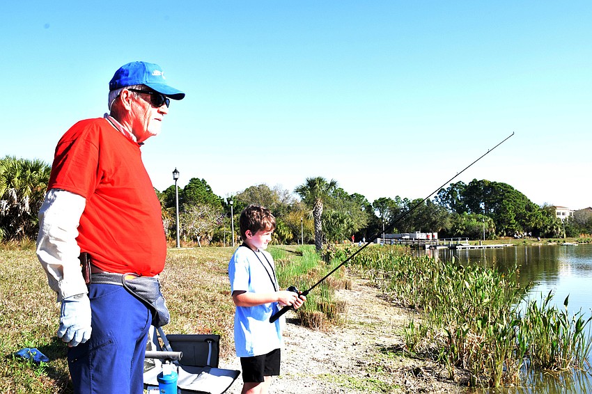 Lakewood Ranch's Ed Van Stedum, who volunteers for the Lakewood Ranch Anglers Club, gives advice to River Club's Jackson Kubitz, who is 10 years old.
