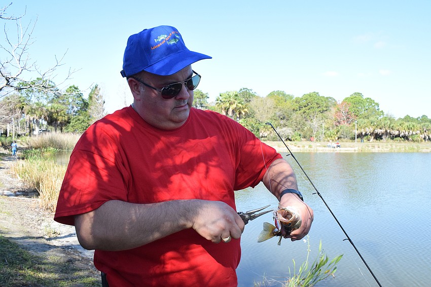 Greenbrook's Ryan Brems, who is a Lakewood Ranch Anglers Club member, takes the hook out of a fish so it can be released back into Lake Uihlein.