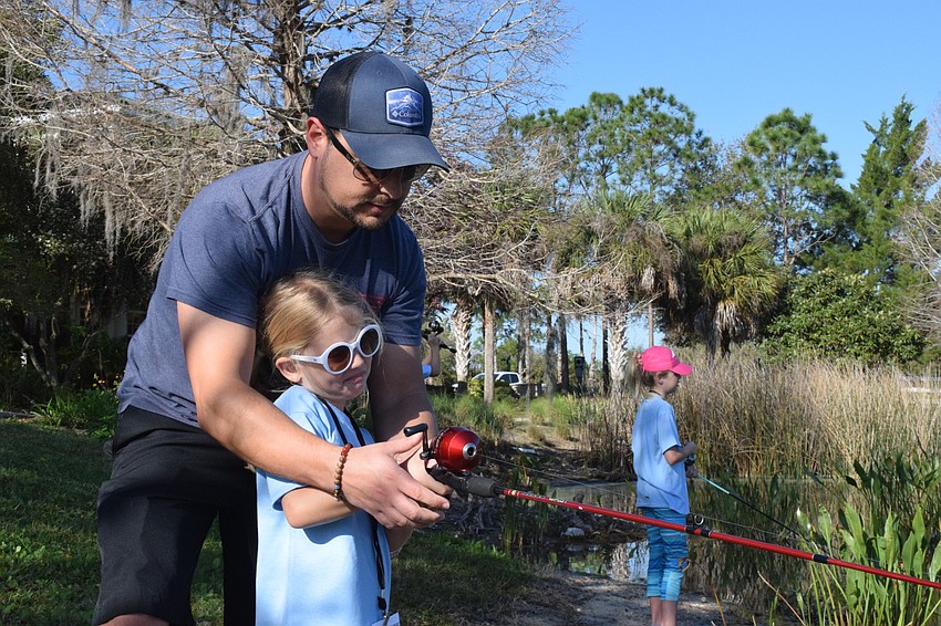Greenbrook's Ray Niecestro helps his 6-year-old daughter Stella Niecestro learn how to gently reel in her line.