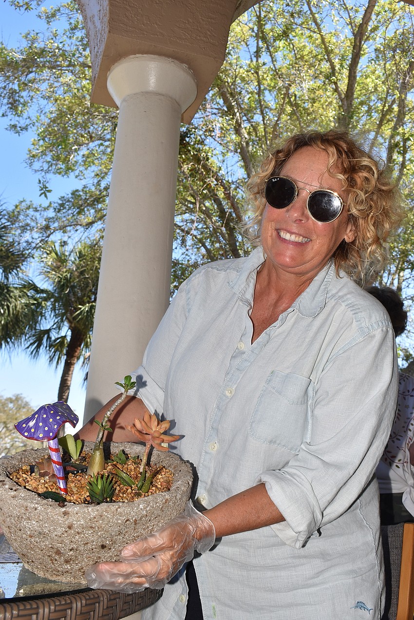 Sandi Love shows off her finished pot, after a few last-minute additions.