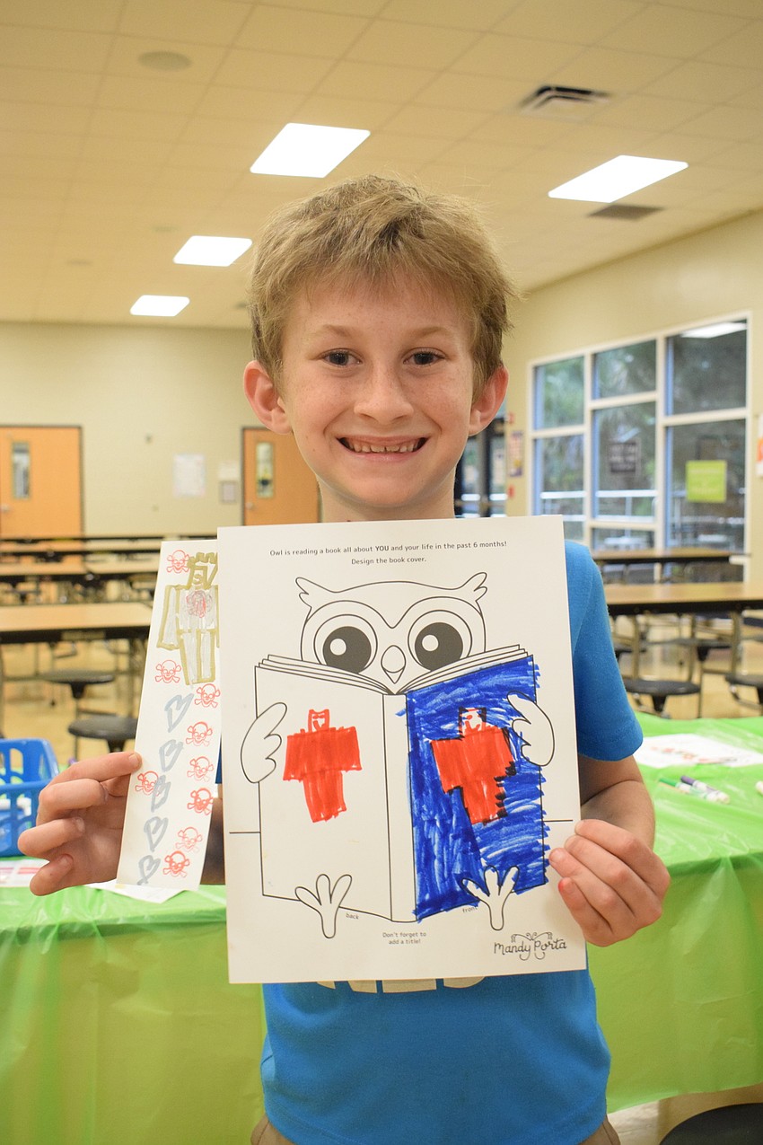 Second grader Ryker Anderson shows off the bookmark and book cover he created.
