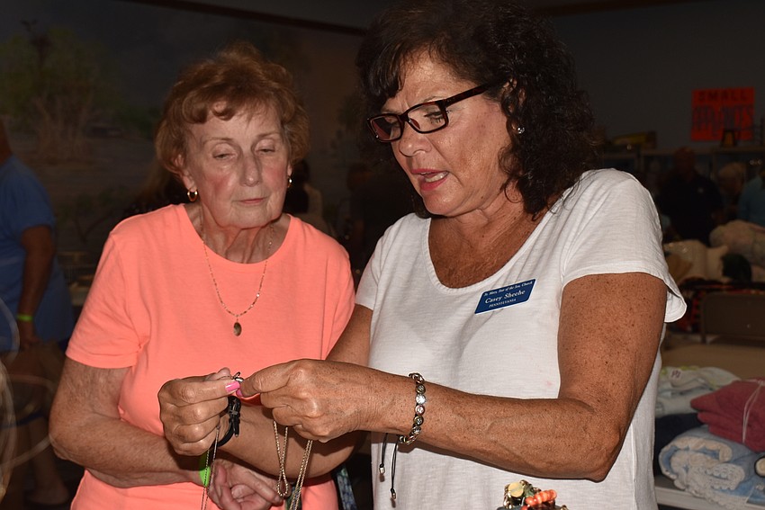 Ellen Jeff and Casey Sheehe examine an engraving on a necklace.
