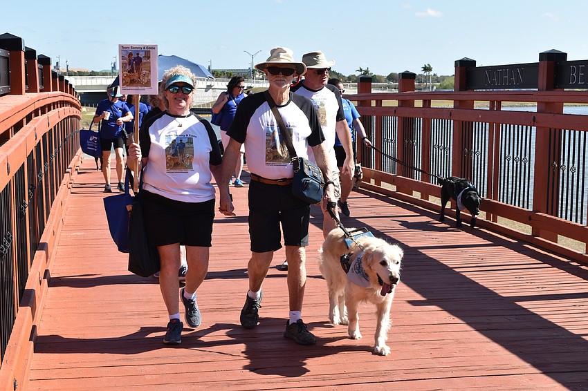 Betty and Ed Burton walk their golden retriever Sammy in honor of Sammy’s late brother, Eddie, at the Suncoast Walkathon on March 5, 2022.