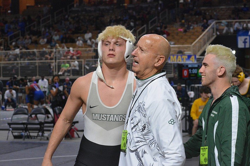 Lakewood Ranch senior Ranson Coons is escorted off the mat by head Coach Pat Ancil and assistant Coach Robert Collier. Coons finished third in the Class 3A 182-pound division.