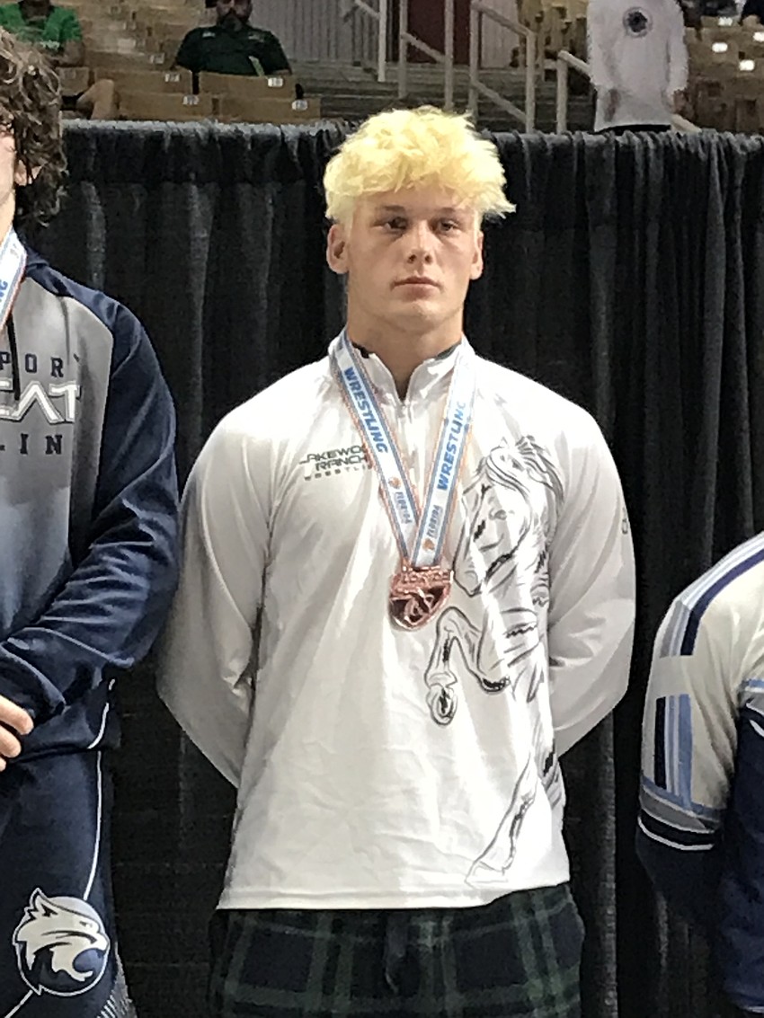 Ranson Coons receives his third-place medal in the Class 3A 182-pound division.
