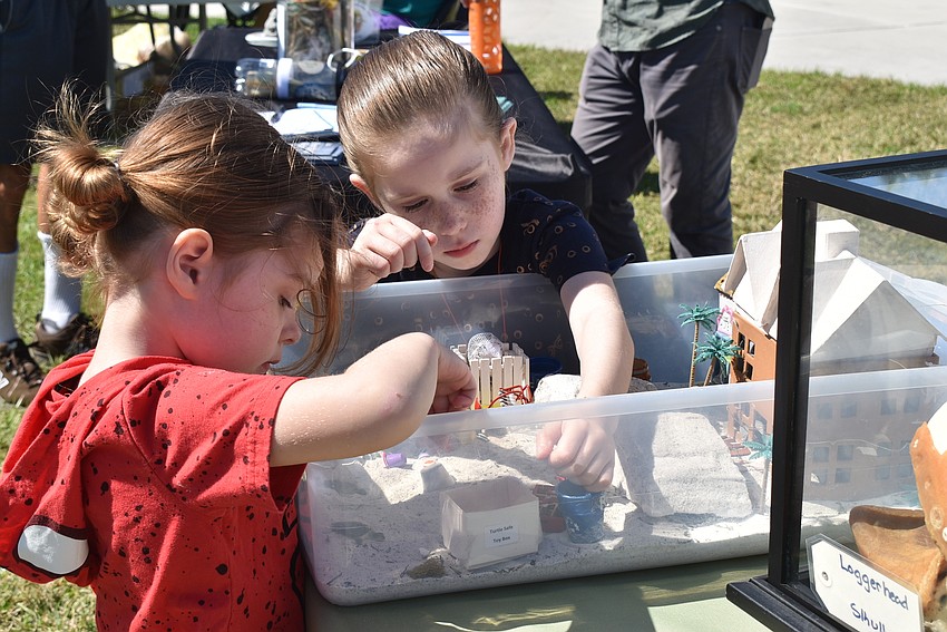 Tori and Bindi Schield search for trash and recycling in the Longboat Key Turtle Watch sand box.