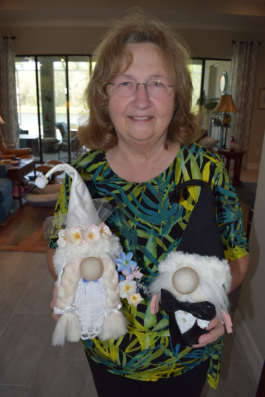 Linda McMillan shows off her bride and groom gnomes.
