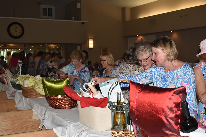 Attendees dropped raffle tickets and placed bids for baskets before lunch.