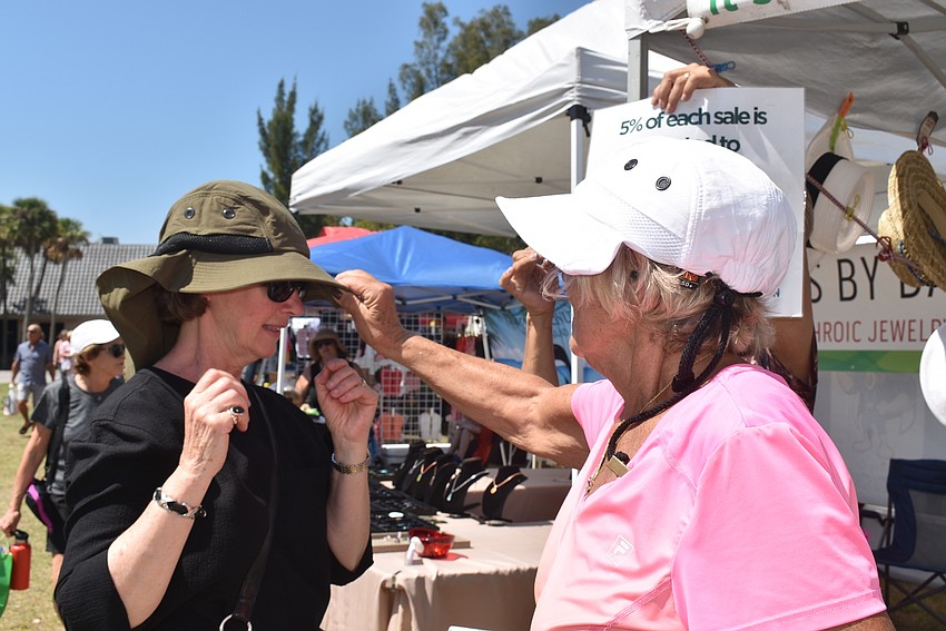 Marilyn Marrotte tries on a hat from Carol Kramitz at SunReady.