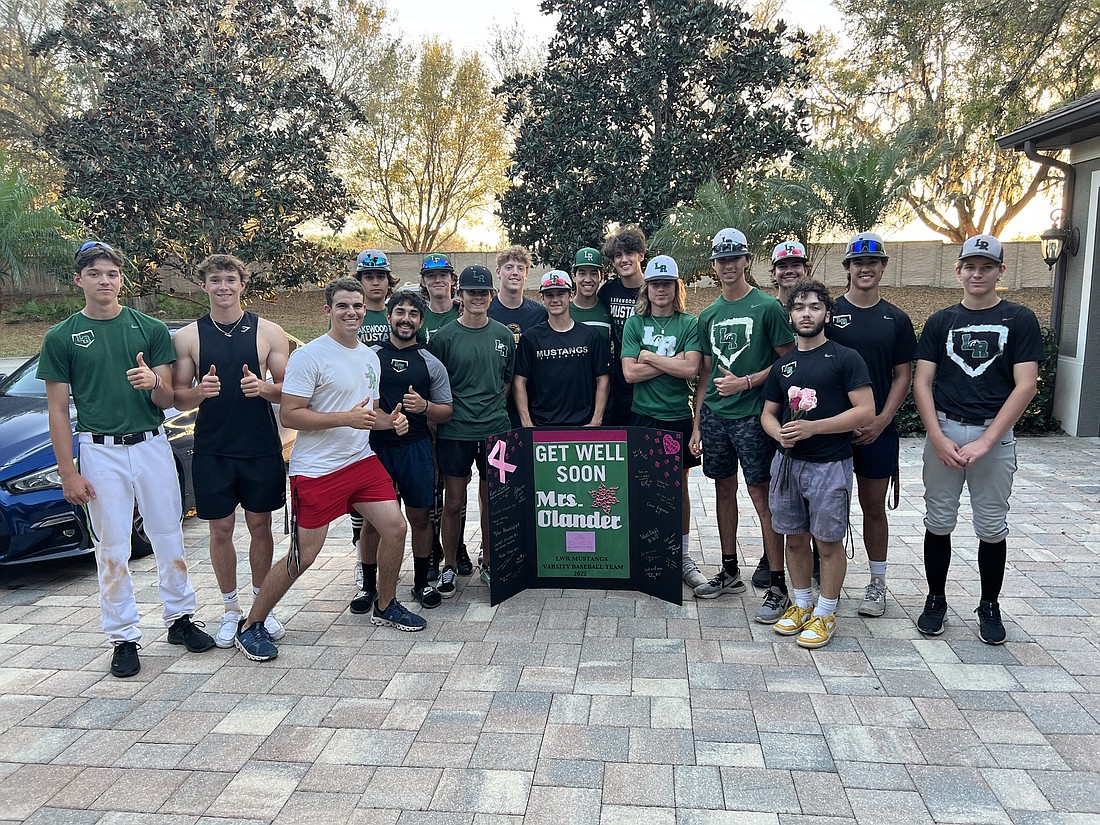 The Lakewood Ranch High baseball team presented Lakewood Ranch resident Chris Olander with roses in the wake of her double mastectomy in February. Senior Ryan Combs (left) spearheaded the effort. Photo courtesy Angela Combs.