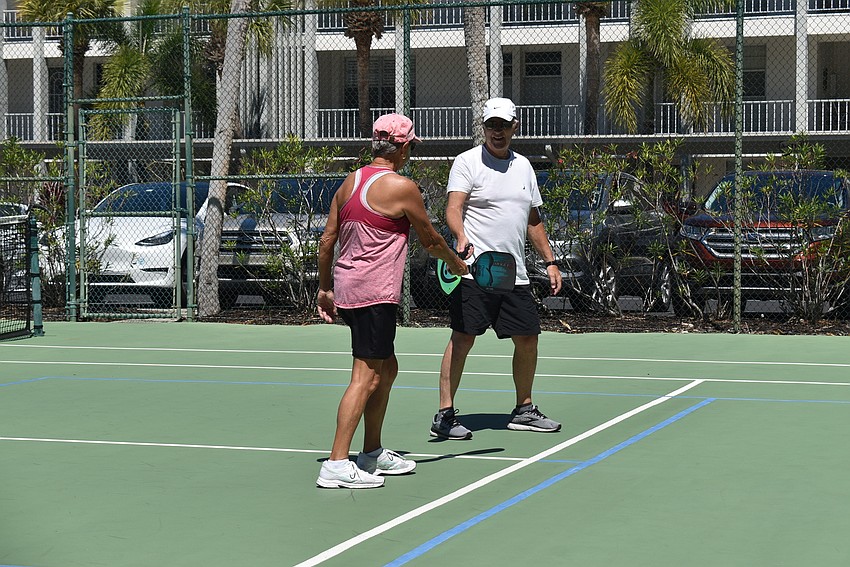Darlene Sedlock and Mac Pratt tap paddles after a good point.