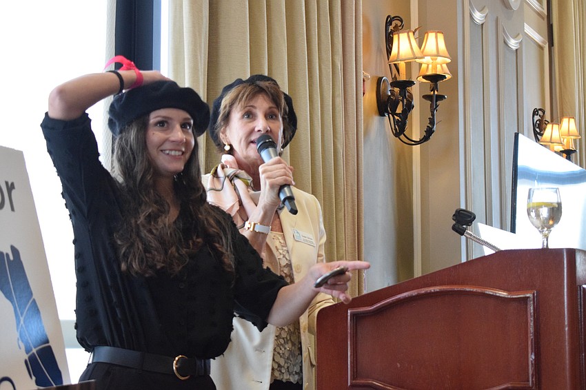 Morgan Tinl, the lead shelter specialist, prepares to flip a coin before Susan Girioux, a member of the nonprofit's board, announces whether it's heads or tails. Players were eliminated until the only one remaining wins a prize.