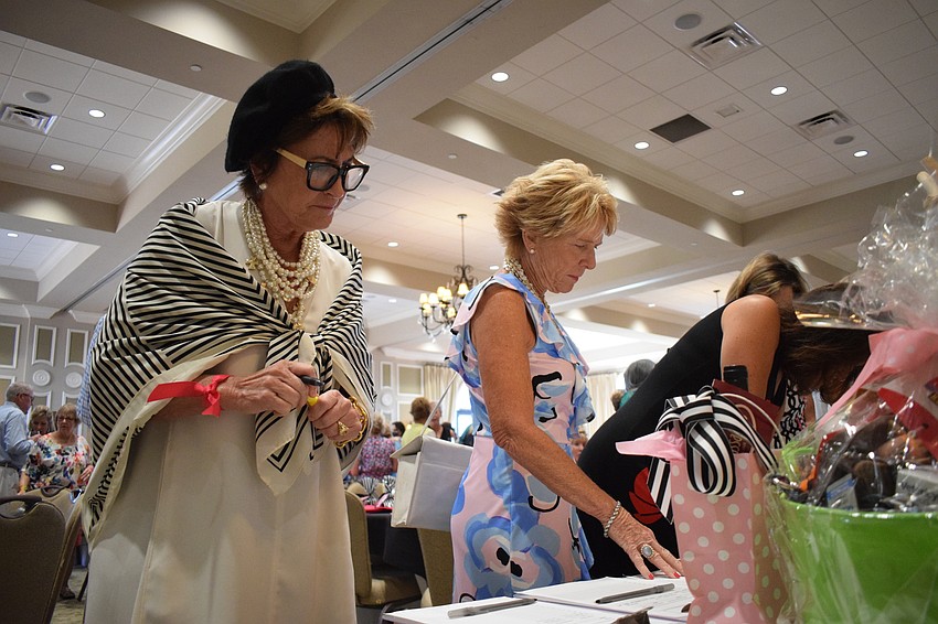 Lakewood Ranch's JoAnn Nicholas and Nancy Bartlett look at the various auction items available.