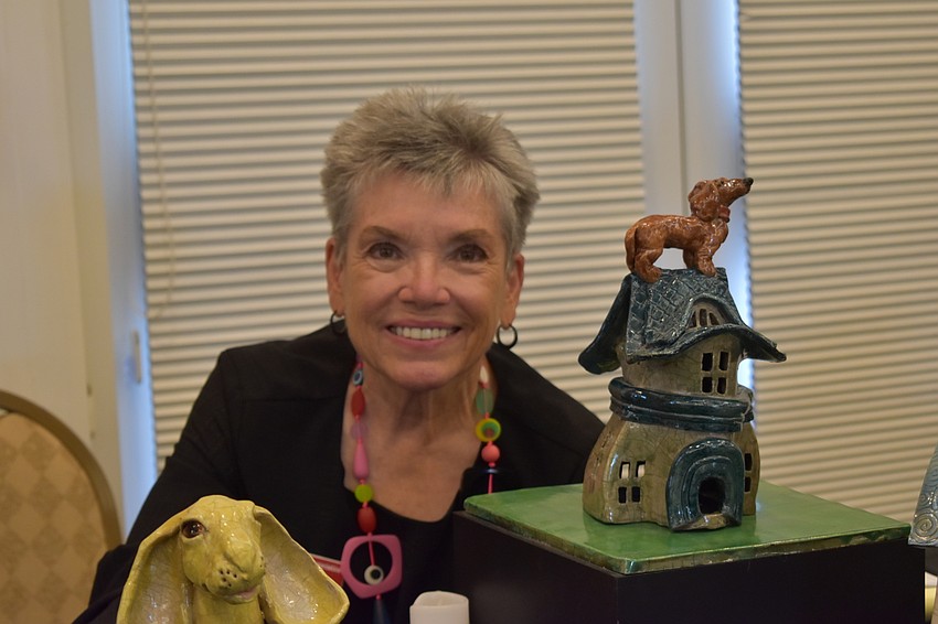 Susan Kerr poses with one of her sculptures, which use a Western variation of Japanese Raku that involves cracking the surface by infusing it with smoke.