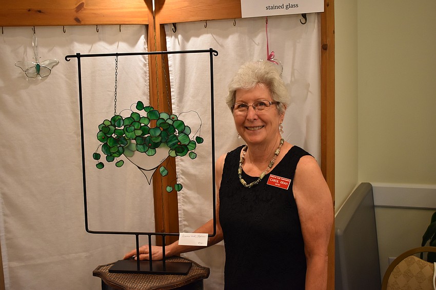 Carol Krah stands beside her stained-glass work 