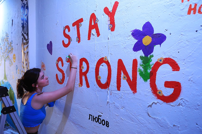 Lia Torrulla paints a message of support.
