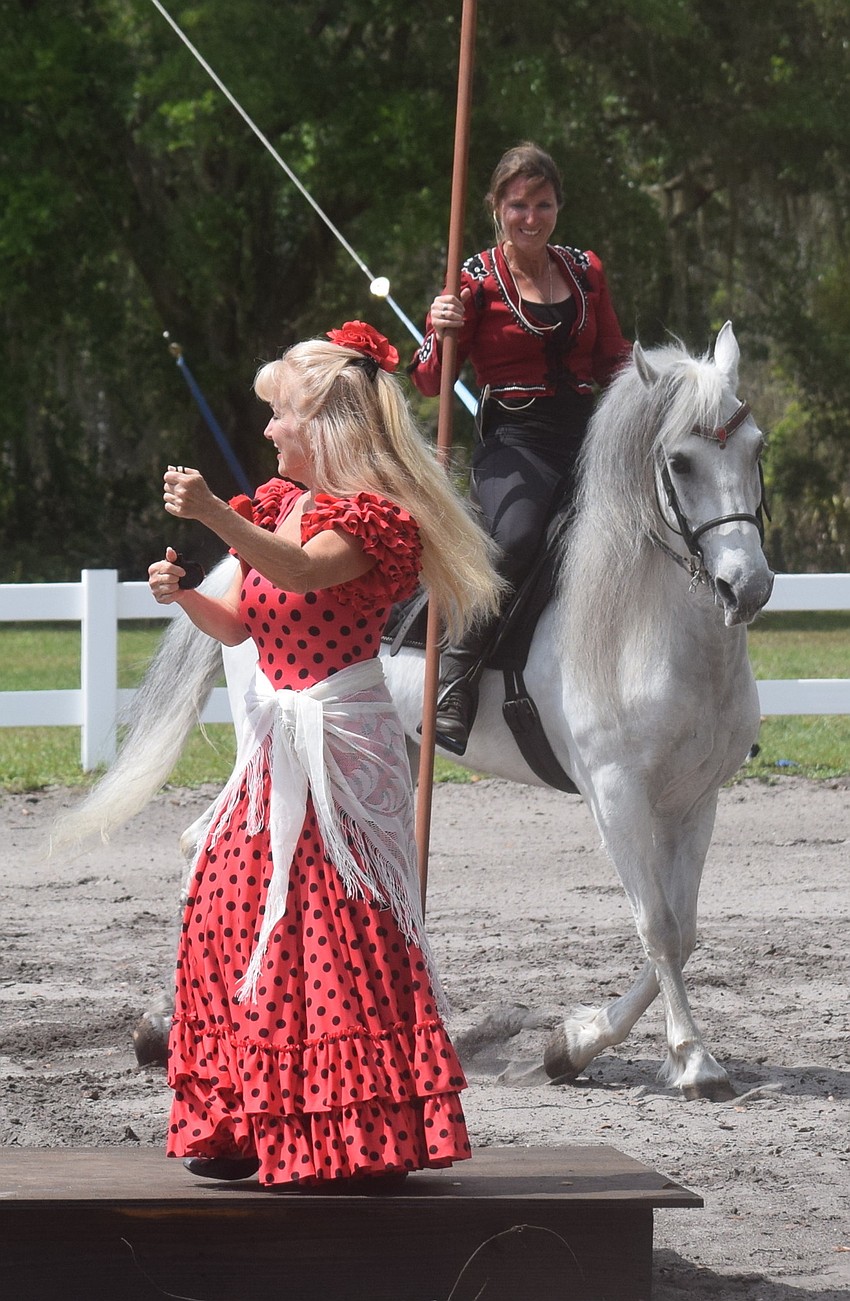 Flamenco dancer Tahja Harrison performs in the center of the arena as Rebecca McCullough displays garrocha  techniques behind her.