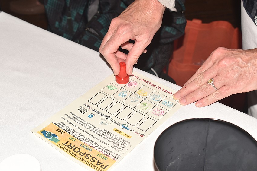 Lisa Baskfield stamps an attendee's passport.