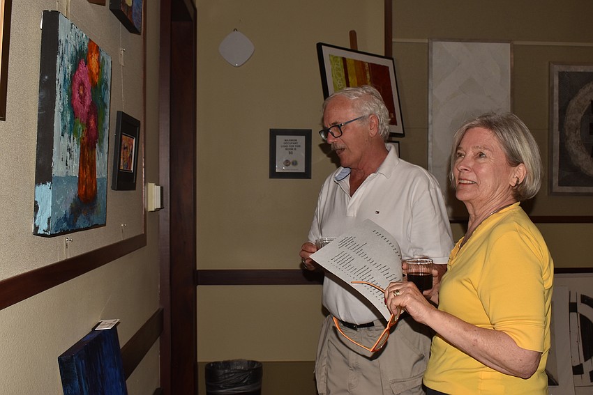 Carolyn Hall and Chuck Malkerton browse some art on the walls.