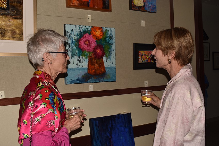 Jane Boyd and Susie Porter discuss a painting.