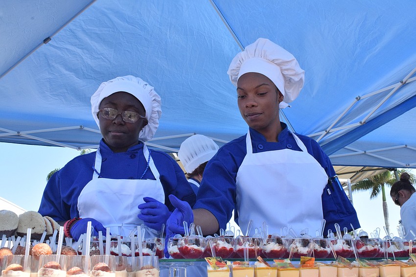 Rhea Scott and Okera Brewster, students in Manatee Technical College's baking program, serve a variety of desserts to the festival's patrons