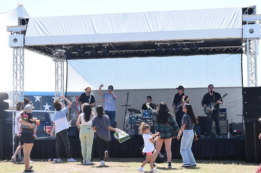 The Derek Lersch Band has people dancing to the music in front of the stage.