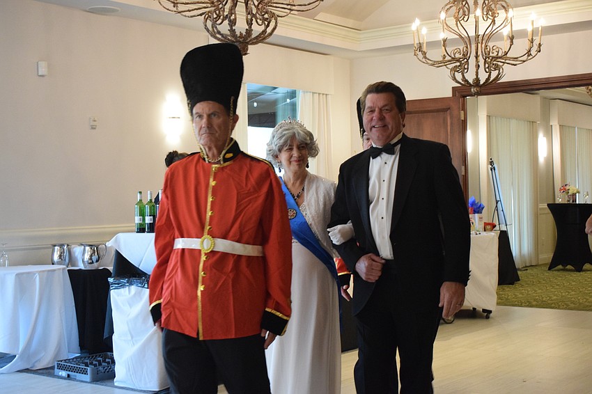 Stoneybrook's Mike Neville dresses as the Queen's Royal Guard as he escorts Sylvia Day, who is portraying Queen Elizabeth II, and Bob Harrigan to the ballroom.